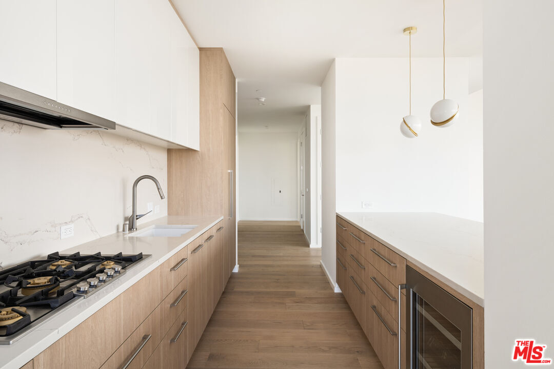 1000 West 8th Street, Unit PH5803 Los Angeles, CA 90017 - Photo 23 of 57 a kitchen with stainless steel appliances granite countertop a sink and cabinets