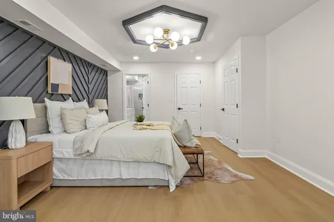 a spacious bedroom with a bed and a chandelier