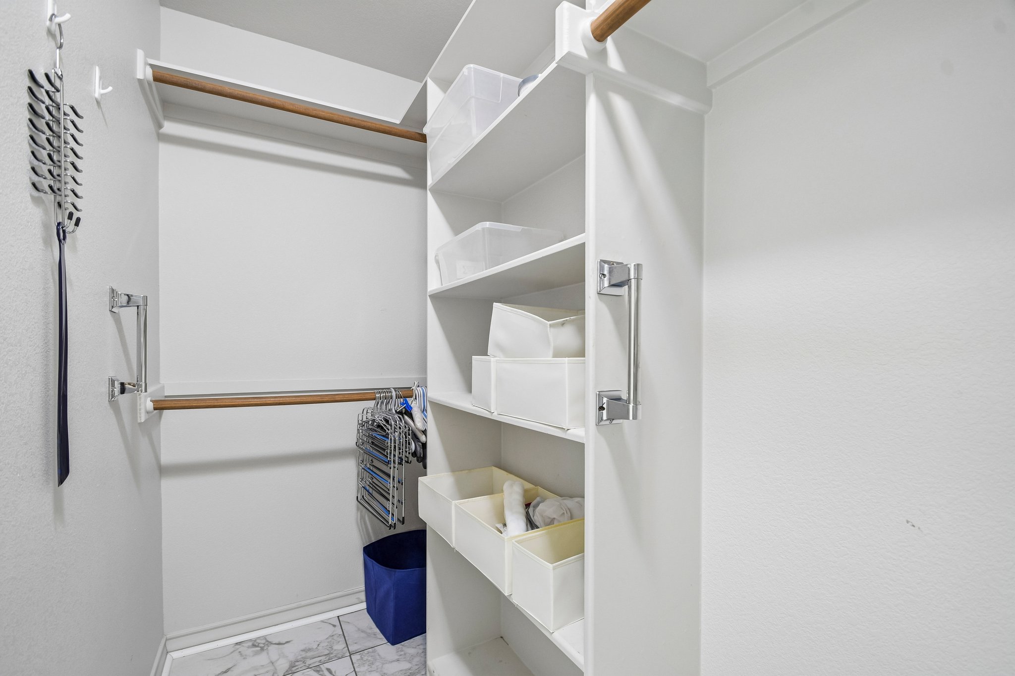 307 West 4th Street Elgin, TX 78621 - Photo 21 of 40 Walk-in closet featuring built-in shelving, dual hanging rods, and marble-finish tile flooring