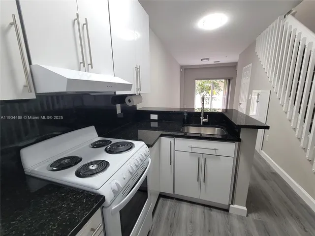 a kitchen with a sink a stove and cabinets