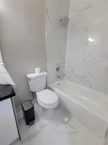 a white bath tub sitting next to a white toilet