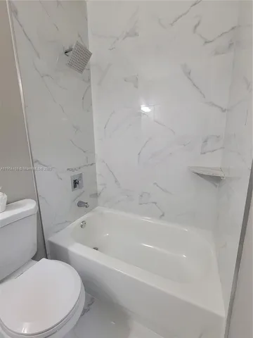 an empty room with wooden floor and a hallway