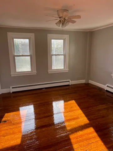 a view of a room with wooden floor and fan