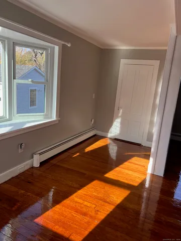 a view of a room with wooden floor and a window