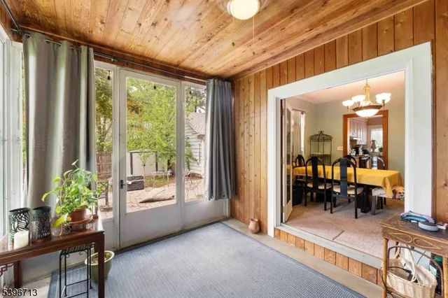 a dining room with wooden floor a chandelier a wooden table and chairs