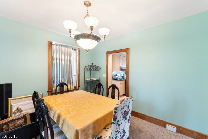 1321 Murray Avenue Plainfield, NJ 07060 - Photo 12 of 13 a dining room with wooden floor a chandelier a wooden table and chairs