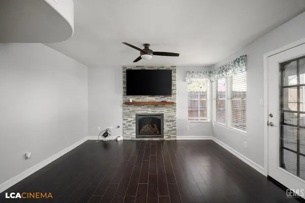 an empty room with ceiling fan and window