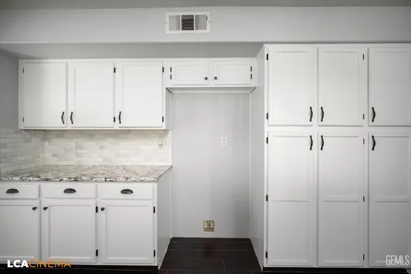 a view of a room with a hardwood floor ceiling fan and windows