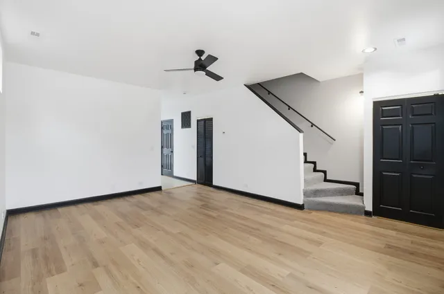 an empty room with closet and a ceiling fan