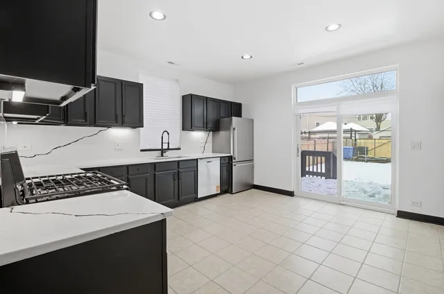 a kitchen with stainless steel appliances a sink and a stove top oven