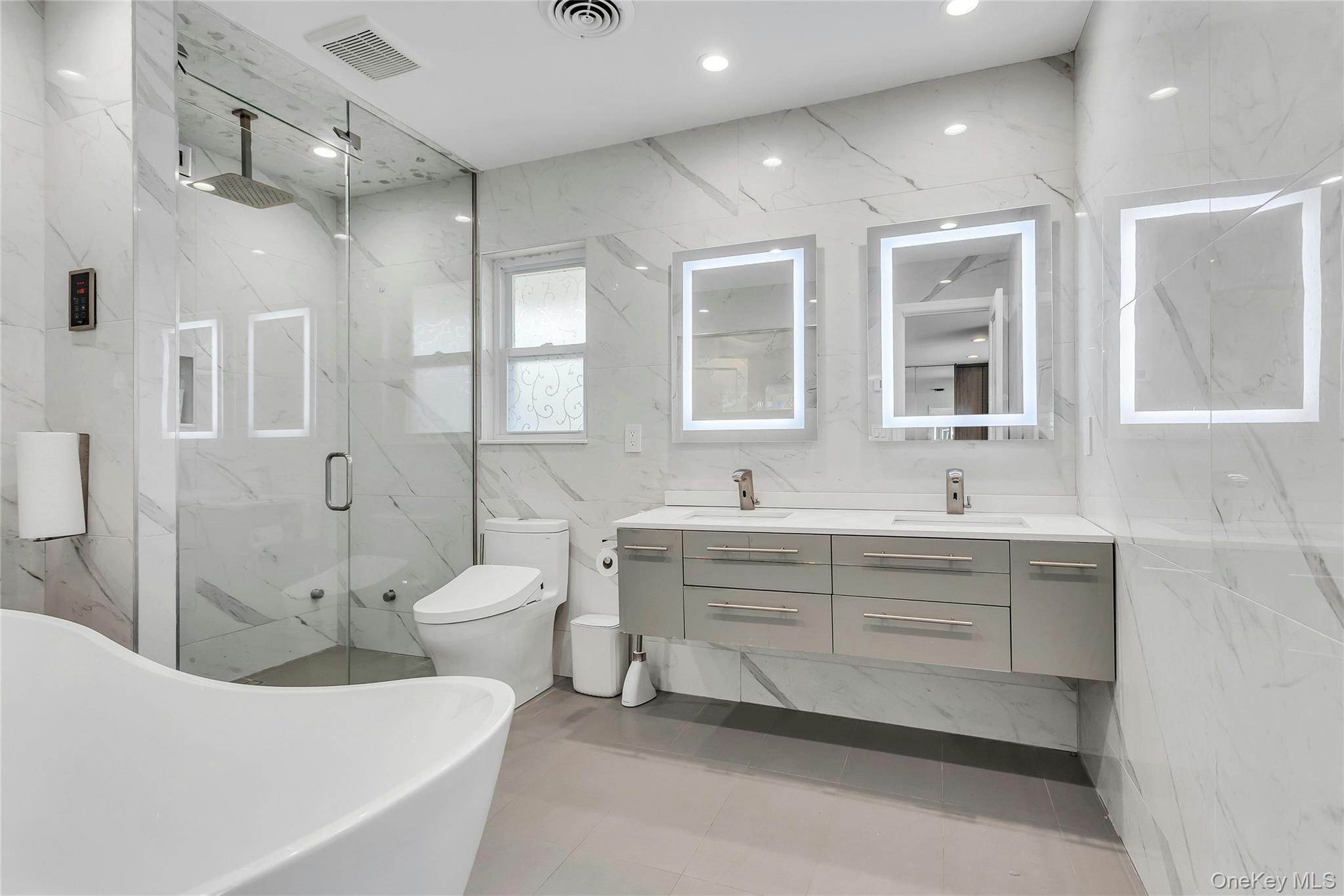 170 Old Courthouse Road Manhasset Hills, NY 11040 - Photo 20 of 35 Full bath featuring double vanity, a marble finish shower, stone wall, recessed lighting, and a soaking tub