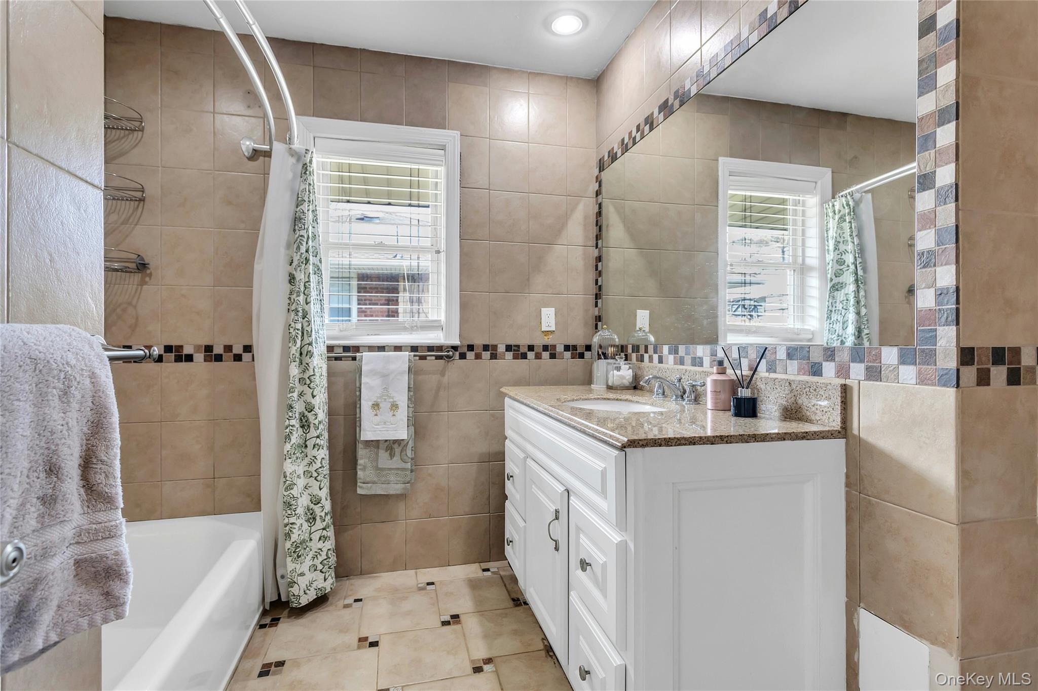 170 Old Courthouse Road Manhasset Hills, NY 11040 - Photo 24 of 35 Family Bathroom featuring vanity, tile walls, shower / bath combination, and light tile patterned floors