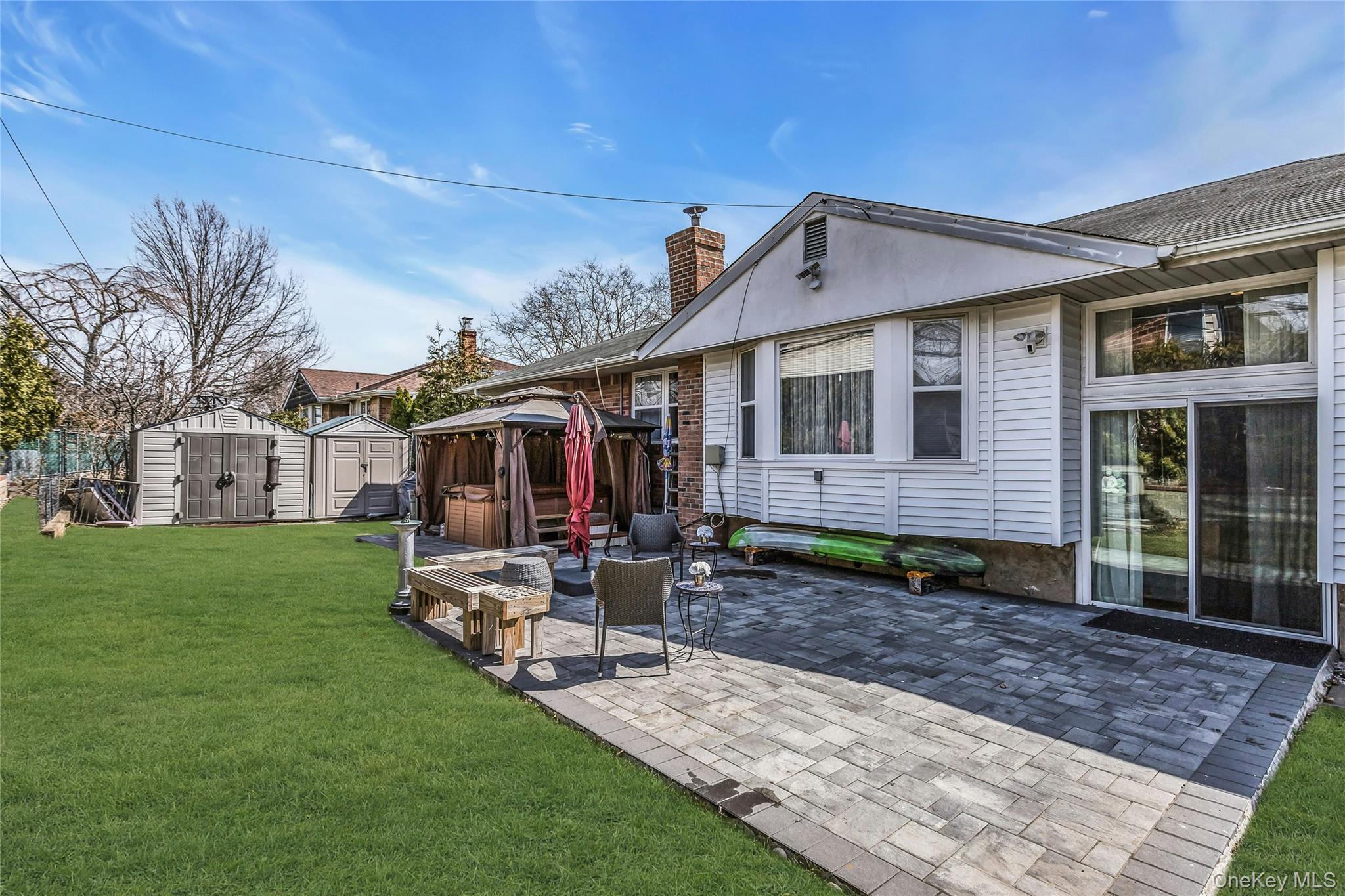 170 Old Courthouse Road Manhasset Hills, NY 11040 - Photo 31 of 35 Landscaped Fenced backyard with Inground sprinkers, a gazebo, gifted hot tub, a paver patio area, and a shed