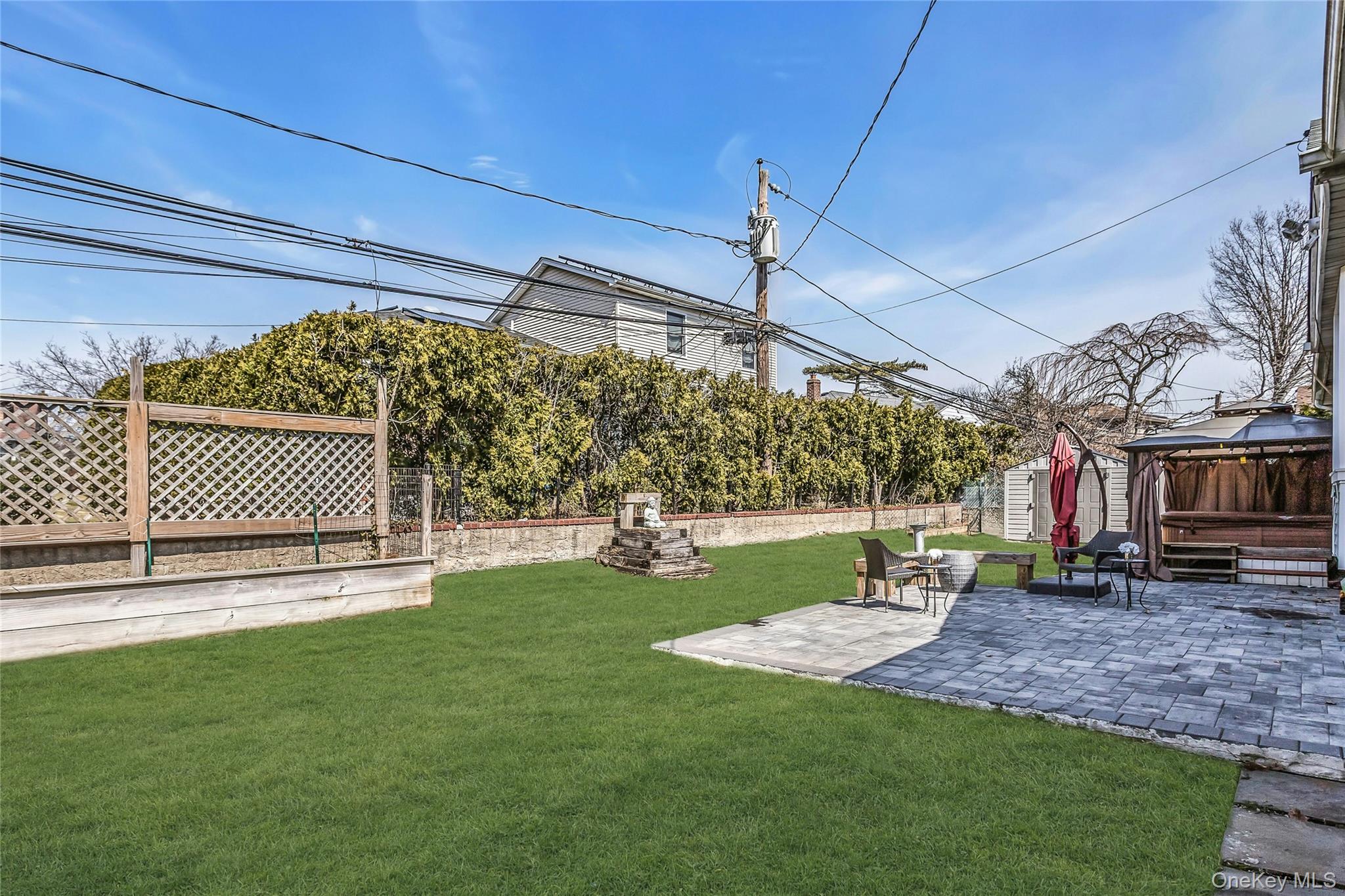 170 Old Courthouse Road Manhasset Hills, NY 11040 - Photo 32 of 35 Landscaped Fenced backyard with Inground sprinkers, a gazebo, gifted hot tub, a paver patio area, and a shed