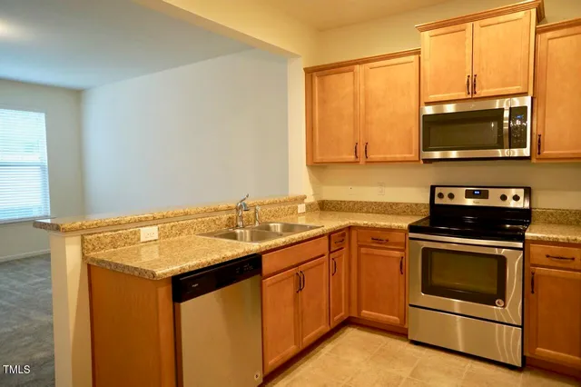 a kitchen with stainless steel appliances granite countertop a sink stove and microwave