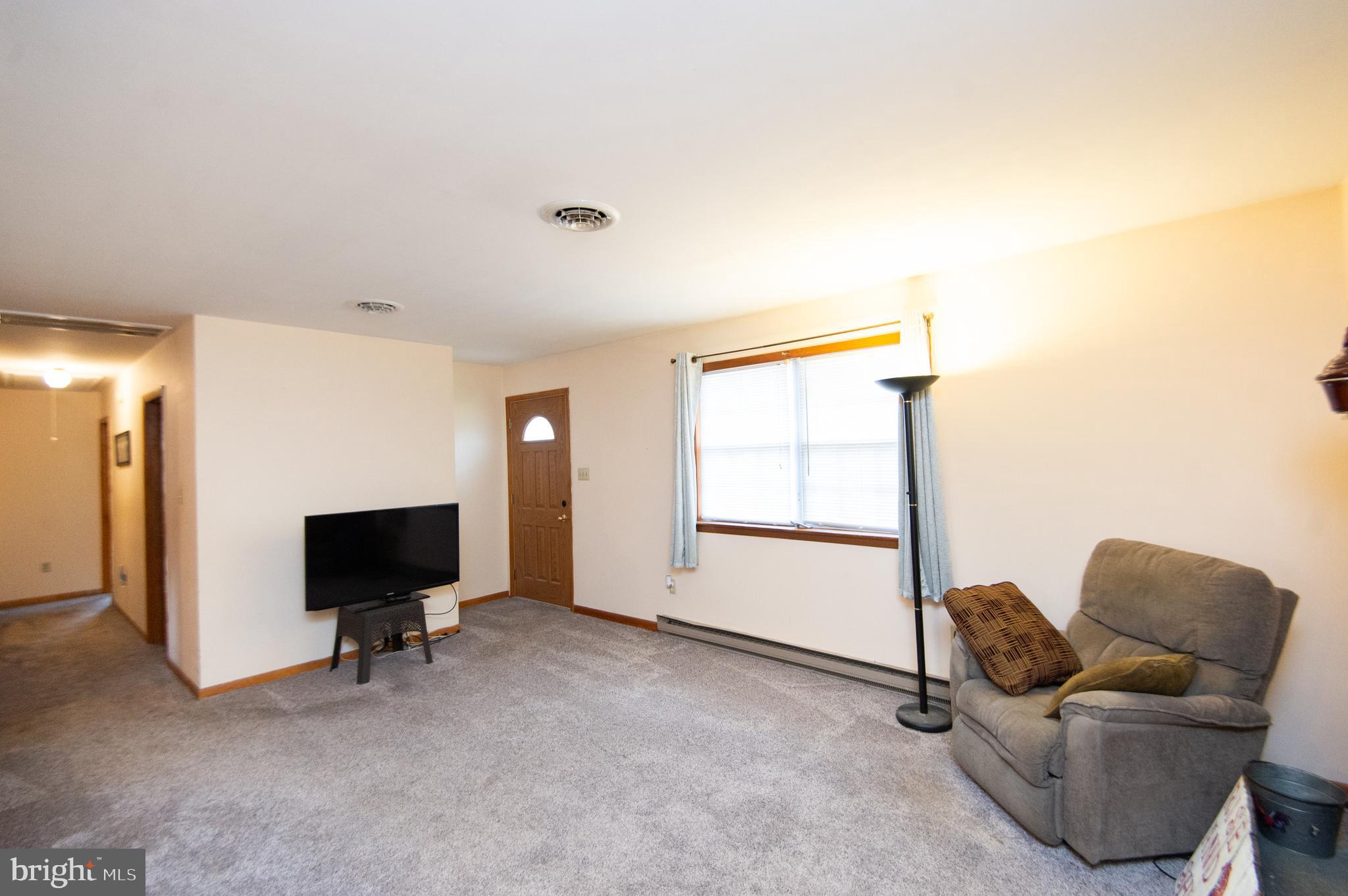 6132 Palmer Mill Road Hurlock, MD 21643 - Photo 11 of 37 a living room with furniture and a flat screen tv