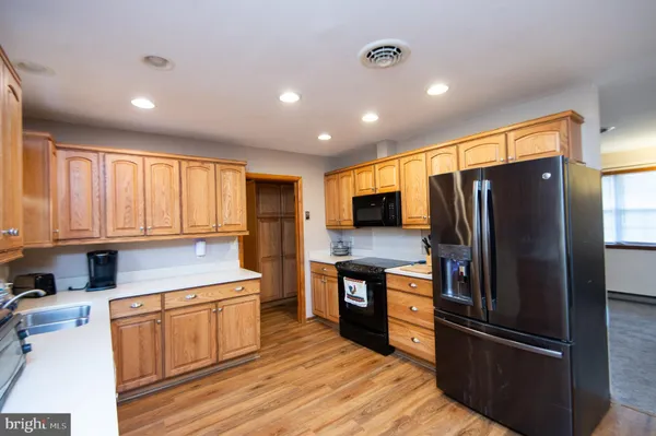 a kitchen with refrigerator cabinets and wooden floor