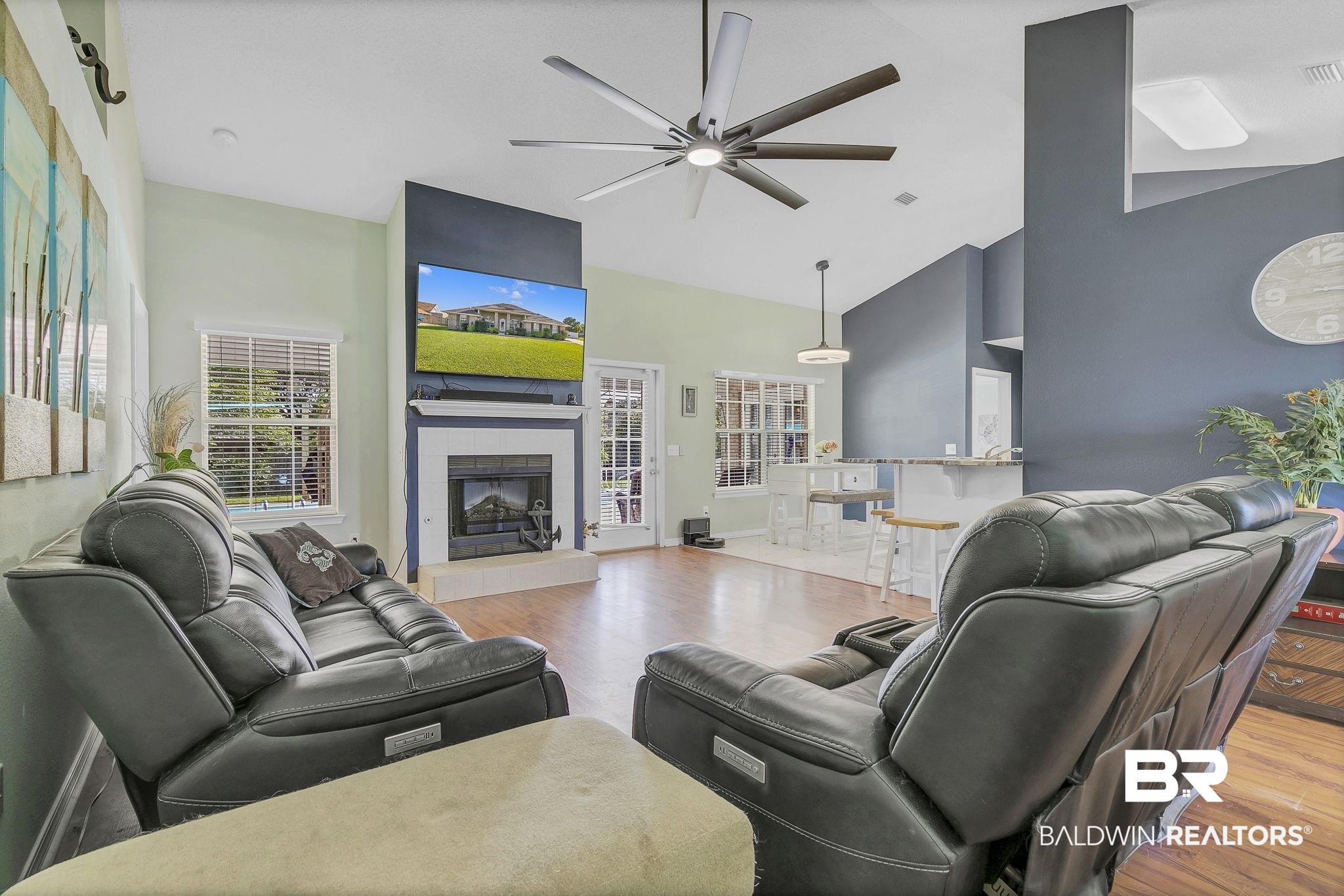 16358 Tempest Drive Foley, AL 36535 - Photo 7 of 46 Living room featuring wood finished floors, visible vents, a ceiling fan, a tiled fireplace, and high vaulted ceiling