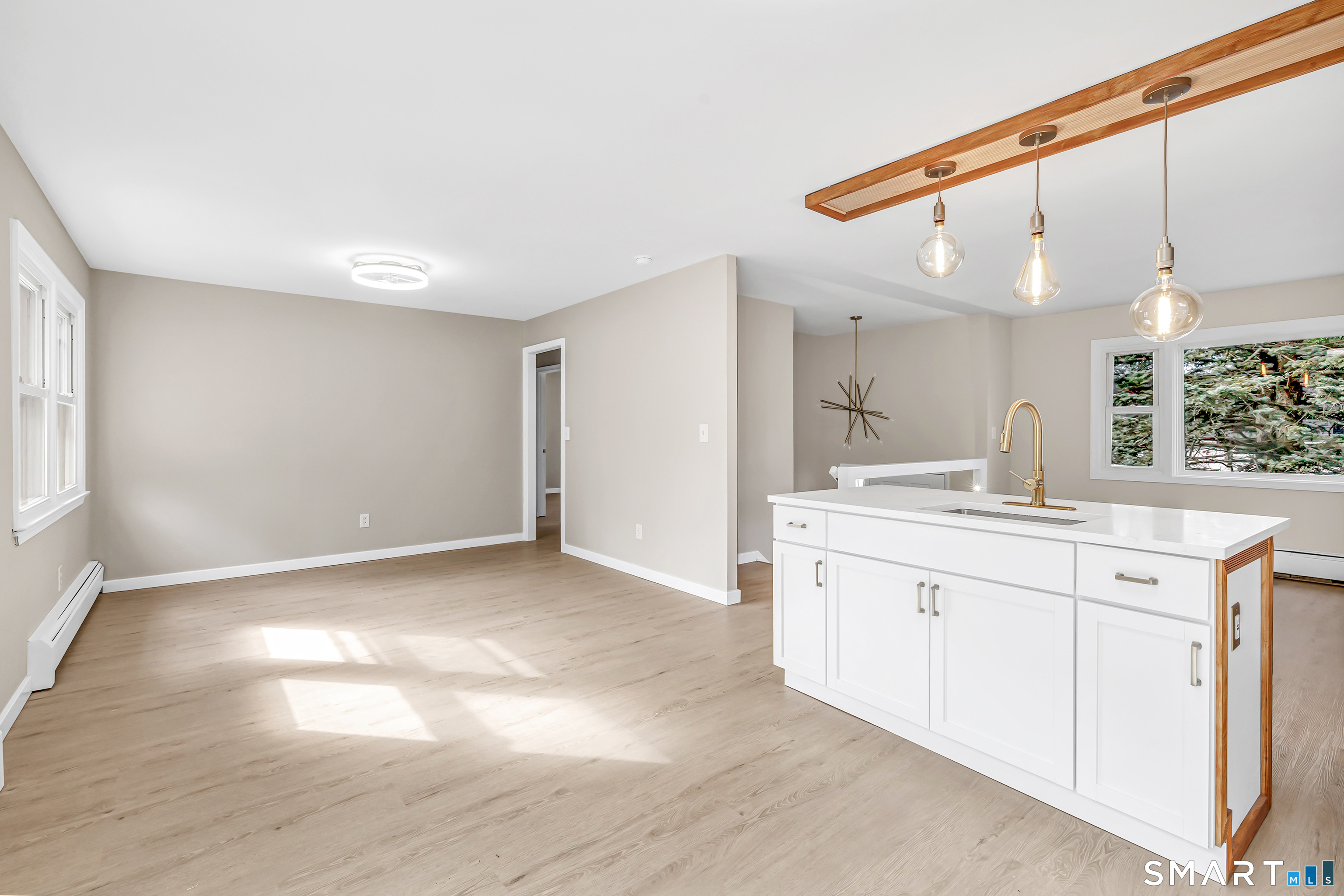 77 Meadow Lark Road Naugatuck, CT 06770 - Photo 13 of 40 Kitchen - White cabinetry, white quartz counter tops with matching custom built island w/ deep sink & electrical outlets, New Sliding Door that leads to rear deck, Freshly painted, installed luxury vinyl floor on both floors,
