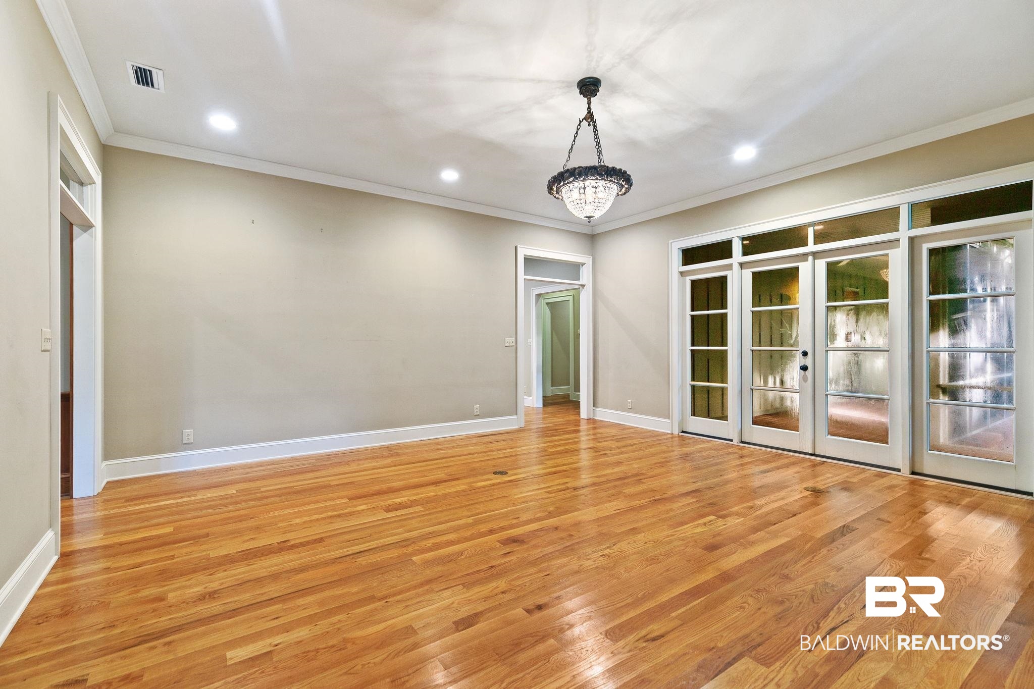 202 Beall Lane Daphne, AL 36526 - Photo 11 of 46 Spare room with a chandelier, light wood-type flooring, and ornamental molding