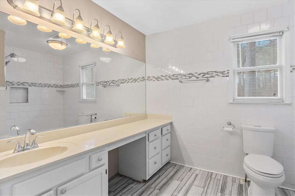 783 Pine Ridge Drive Stone Mountain, GA 30087 - Photo 21 of 32 a bathroom with a sink a toilet and a mirror