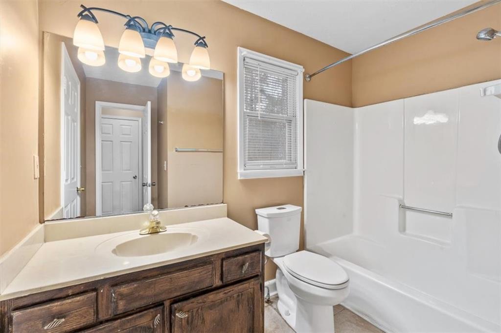 783 Pine Ridge Drive Stone Mountain, GA 30087 - Photo 26 of 32 a bathroom with a sink a toilet a mirror and shower