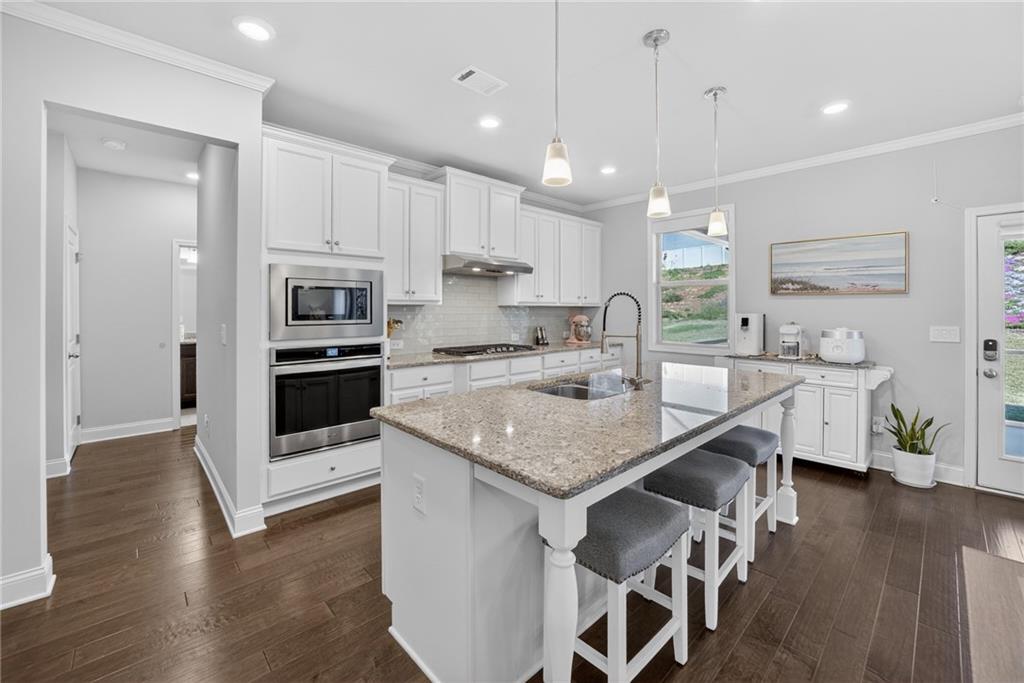 3586 Andover Way Buford, GA 30519 - Photo 17 of 63 a kitchen with stainless steel appliances granite countertop a sink a stove a refrigerator and a oven with wooden floor