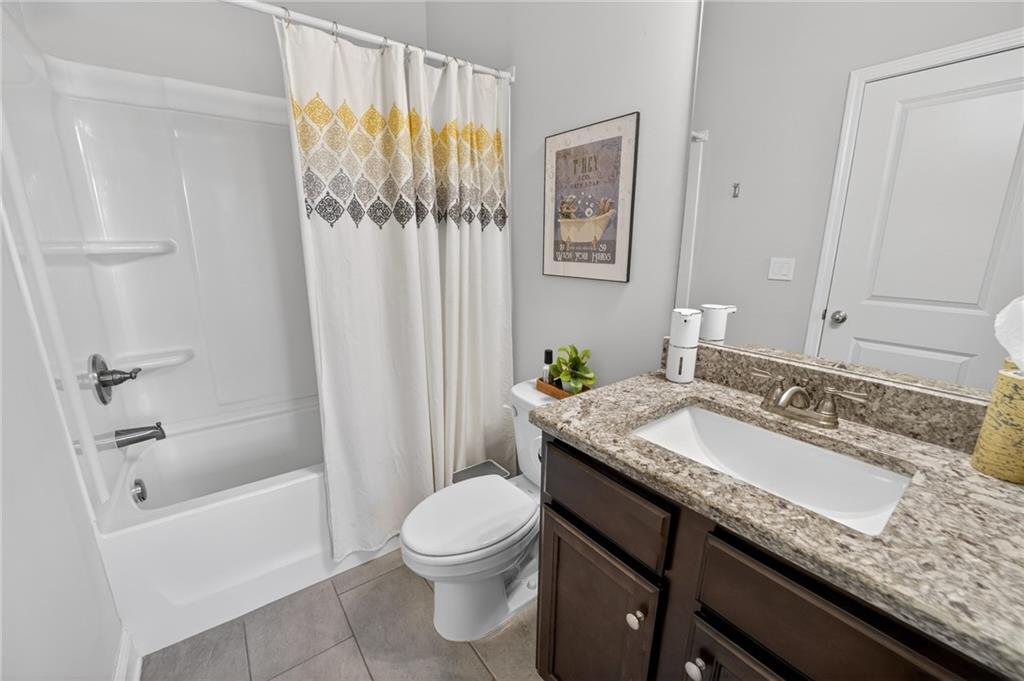 3586 Andover Way Buford, GA 30519 - Photo 19 of 63 a bathroom with a granite countertop sink a toilet and shower
