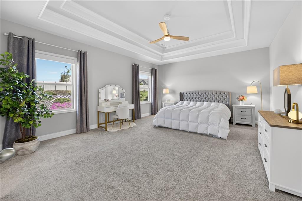 3586 Andover Way Buford, GA 30519 - Photo 24 of 63 a spacious bedroom with a bed and a chandelier