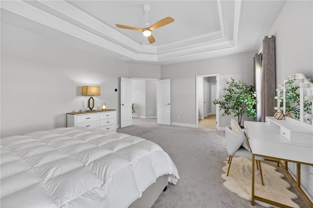 3586 Andover Way Buford, GA 30519 - Photo 25 of 63 a spacious bedroom with a bed and a table