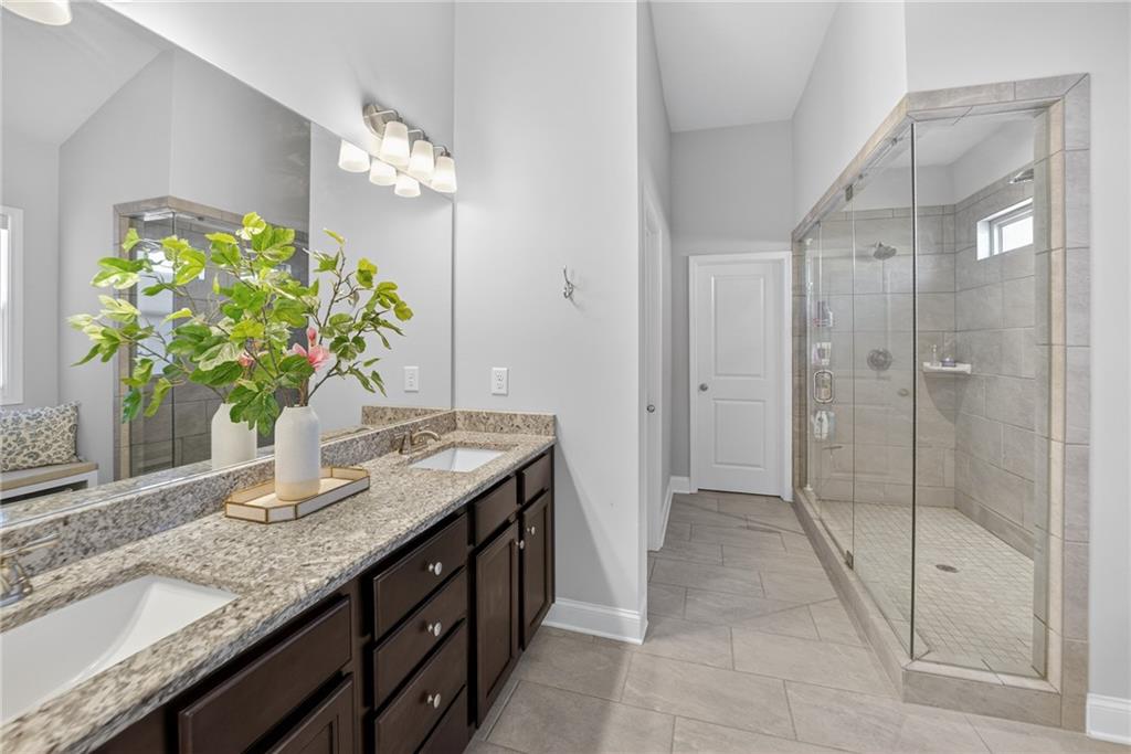 3586 Andover Way Buford, GA 30519 - Photo 26 of 63 a bathroom with a granite countertop sink a toilet and a shower