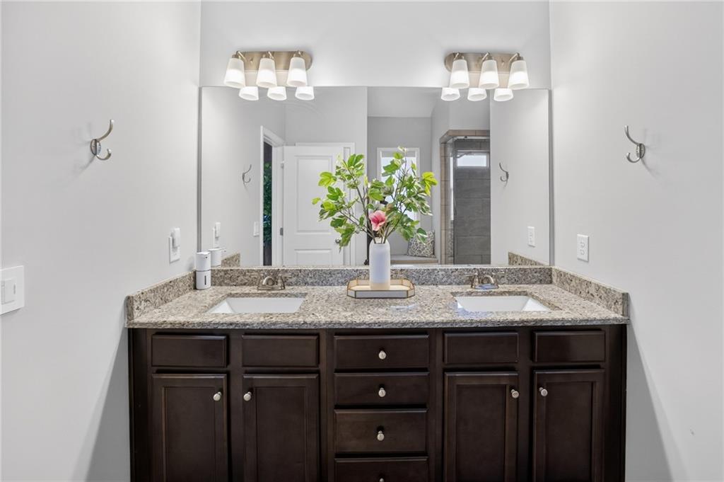 3586 Andover Way Buford, GA 30519 - Photo 27 of 63 a bathroom with a granite countertop sink and a mirror