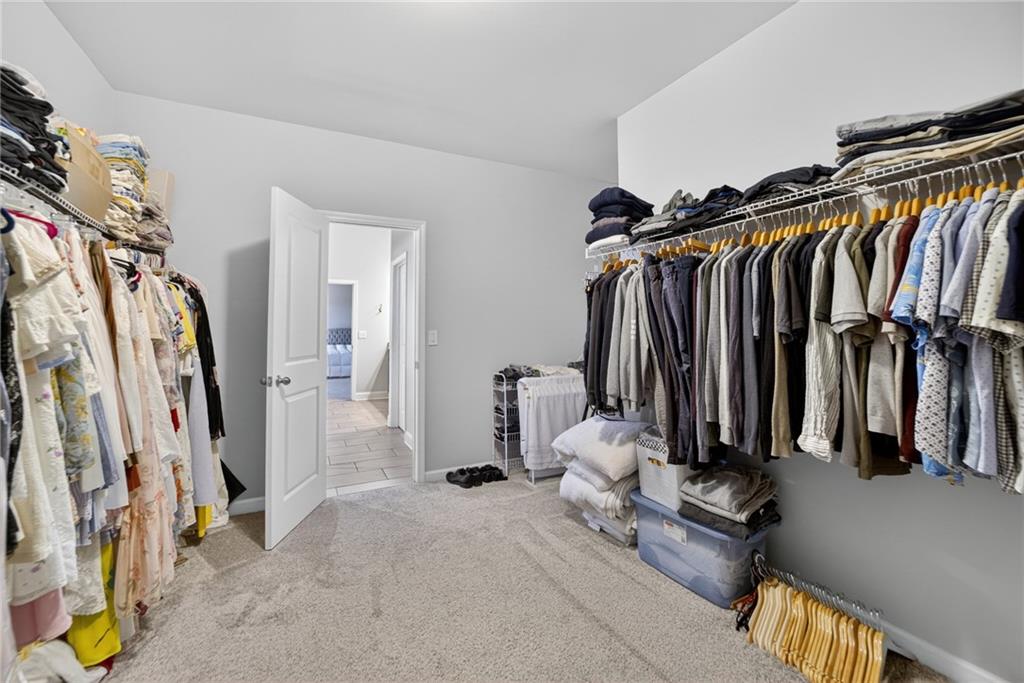 3586 Andover Way Buford, GA 30519 - Photo 30 of 63 a view of walk in closet with clothes and shoes
