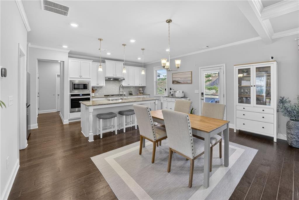 3586 Andover Way Buford, GA 30519 - Photo 5 of 63 a dining room with stainless steel appliances kitchen island granite countertop a dining table chairs and view living room