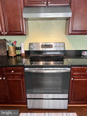 a kitchen with granite countertop a sink cabinets and stainless steel appliances