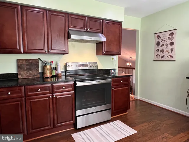 a kitchen with granite countertop wooden cabinets and stainless steel appliances