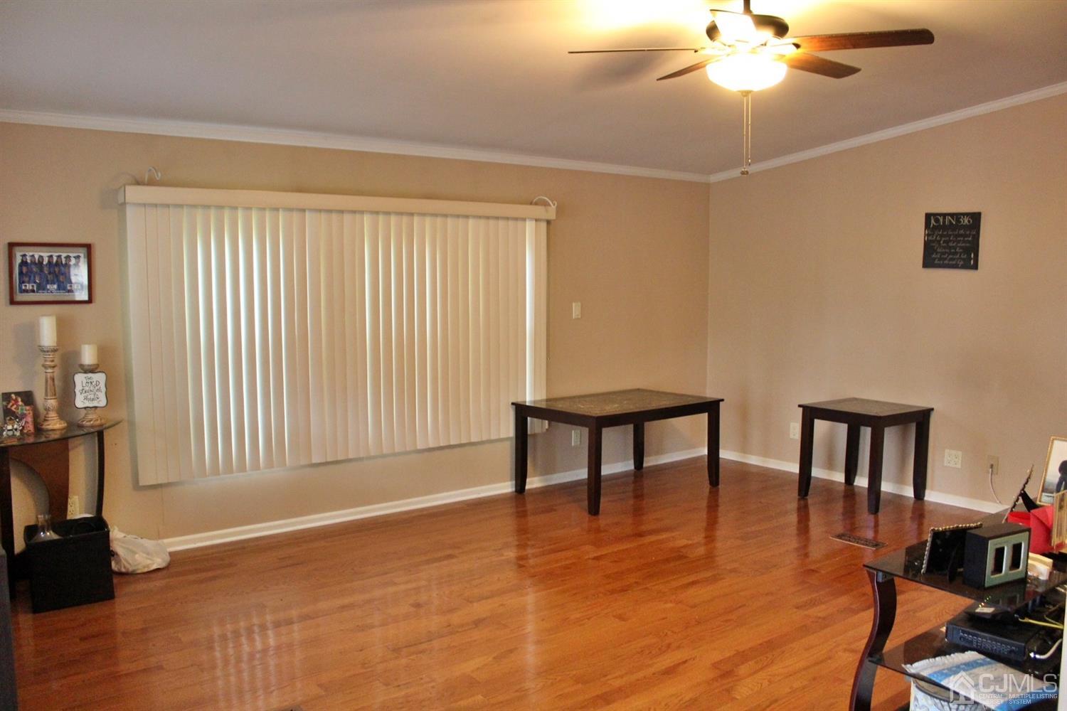 4 Longfellow Road North Brunswick, NJ 08902 - Photo 4 of 10 a view of an empty room with a window and wooden floor