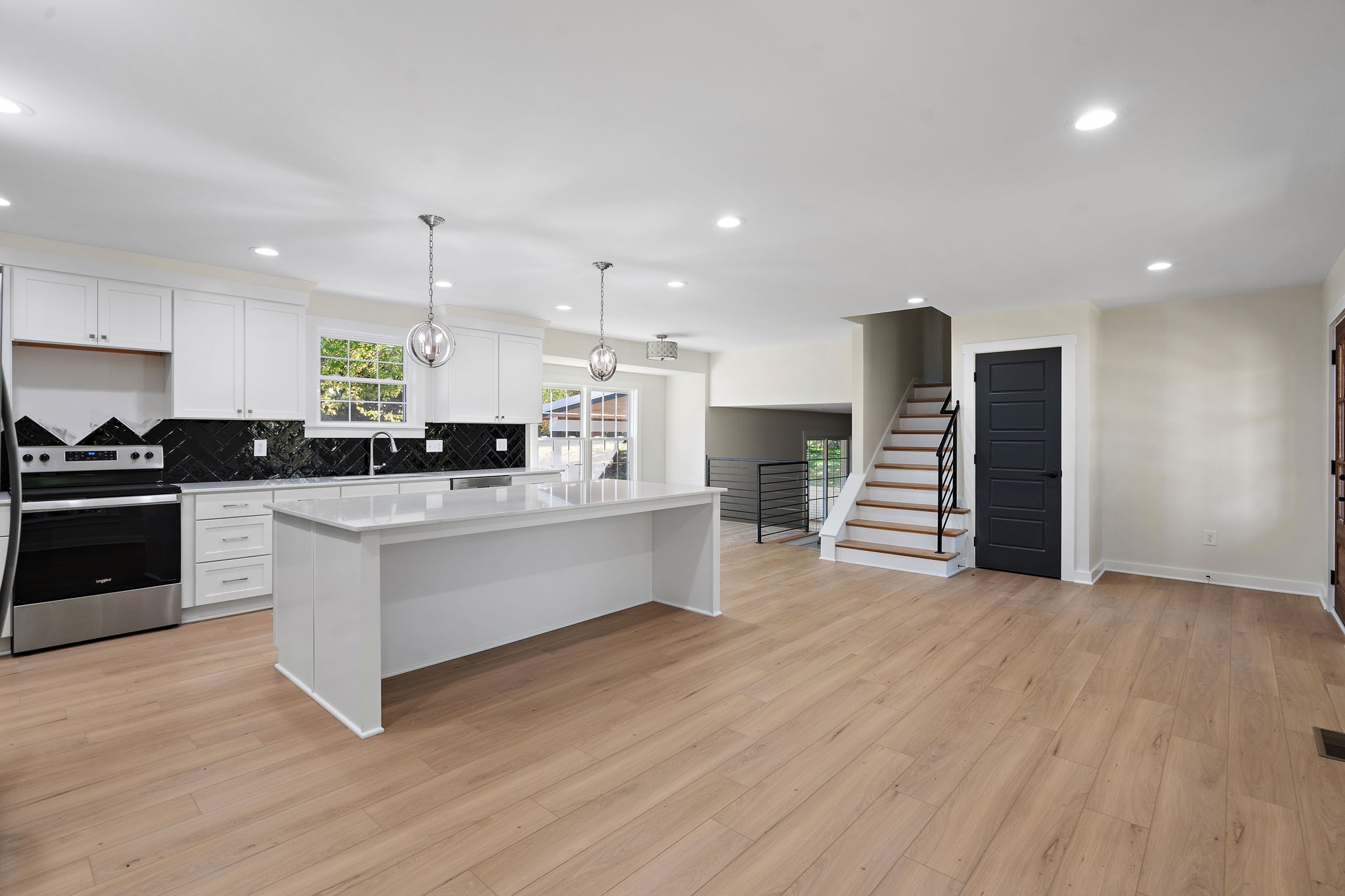 1015 Lock 4 Road Gallatin, TN 37066 - Photo 10 of 47 a large white kitchen with wooden floors stainless steel appliances and white cabinets