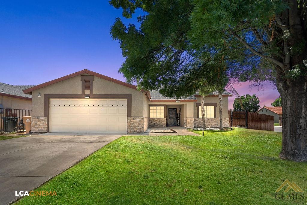 Undisclosed Address Bakersfield, CA 93307 - Photo 2 of 18 a front view of a house with a yard and garage
