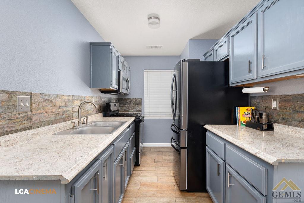 Undisclosed Address Bakersfield, CA 93307 - Photo 9 of 18 a kitchen with stainless steel appliances granite countertop a sink stove and refrigerator