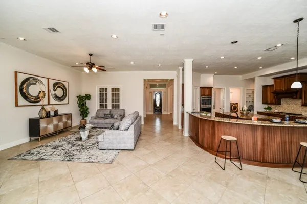 a large living room with stainless steel appliances furniture a rug and a kitchen view