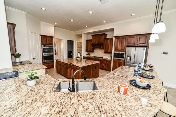 a kitchen with stainless steel appliances kitchen island granite countertop a sink and cabinets