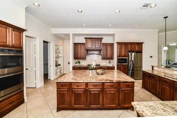 a kitchen with stainless steel appliances granite countertop a stove refrigerator and cabinets