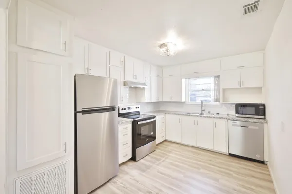 a kitchen with white cabinets and white appliances
