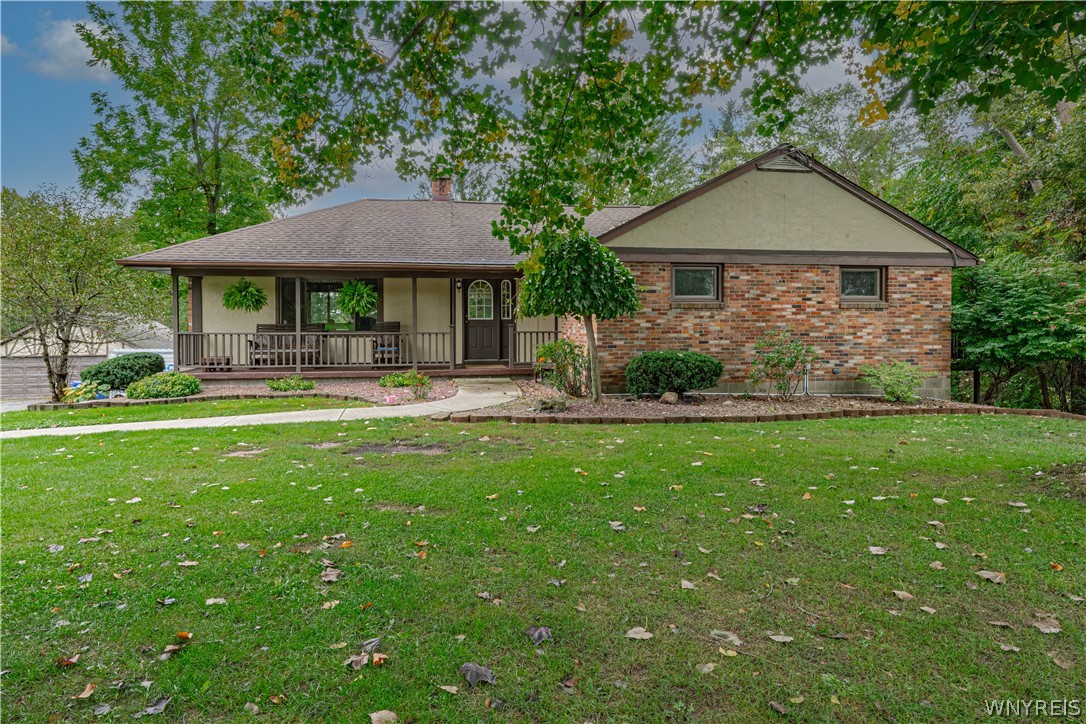 Mature trees frame a welcoming front porch and classic brick exterior on this quiet lot.