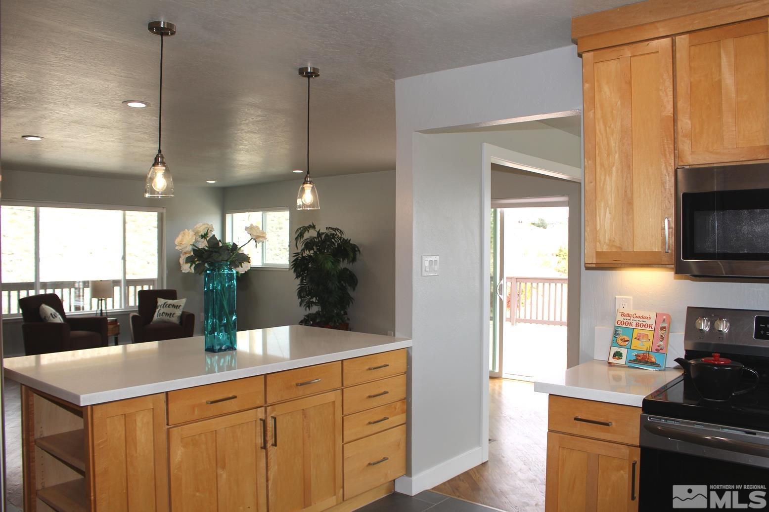 7775 Tamra Drive Reno, NV 89506 - Photo 8 of 40 a kitchen with stainless steel appliances kitchen island granite countertop a sink a stove and a wooden floors