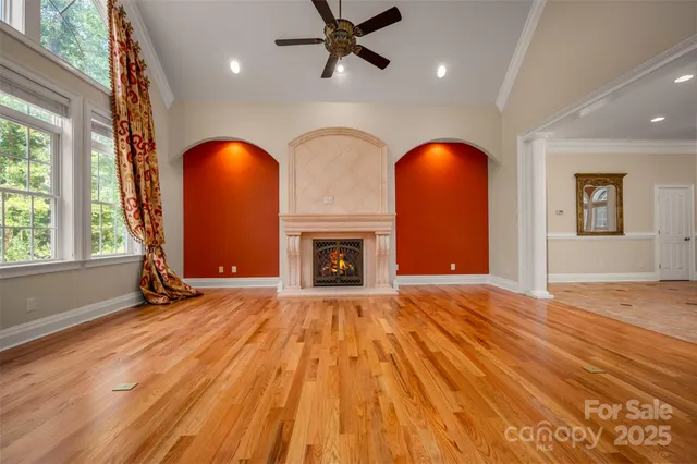 a view of empty room with wooden floor and fireplace