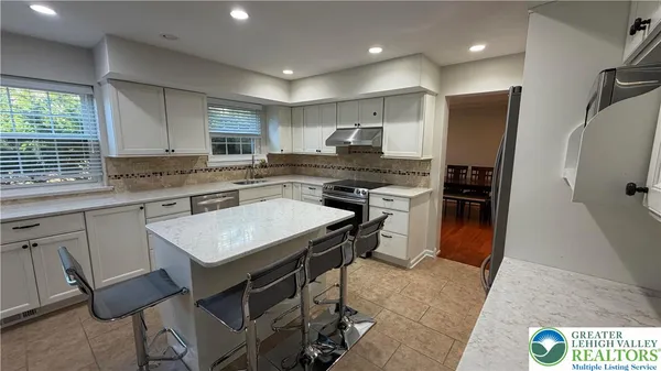 a kitchen with kitchen island a sink stove and refrigerator
