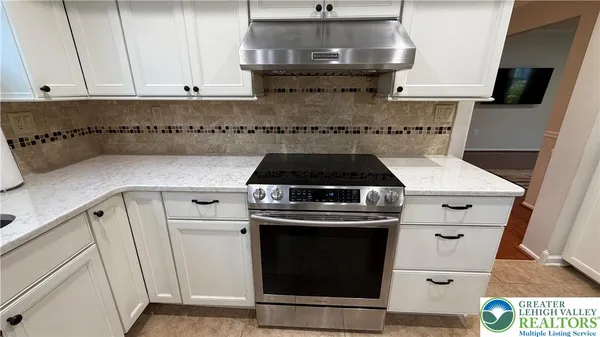 a kitchen with a stove and white cabinets