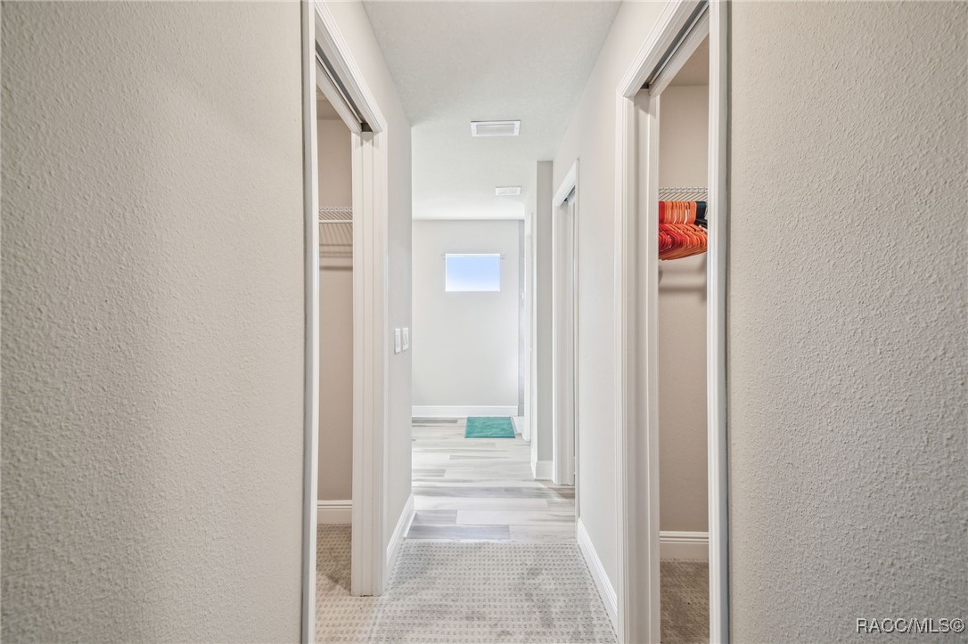 65 East Boston Street Hernando, FL 34442 - Photo 41 of 100 entrance to double walk-in closets on both sides and primary bathroom straight ahead